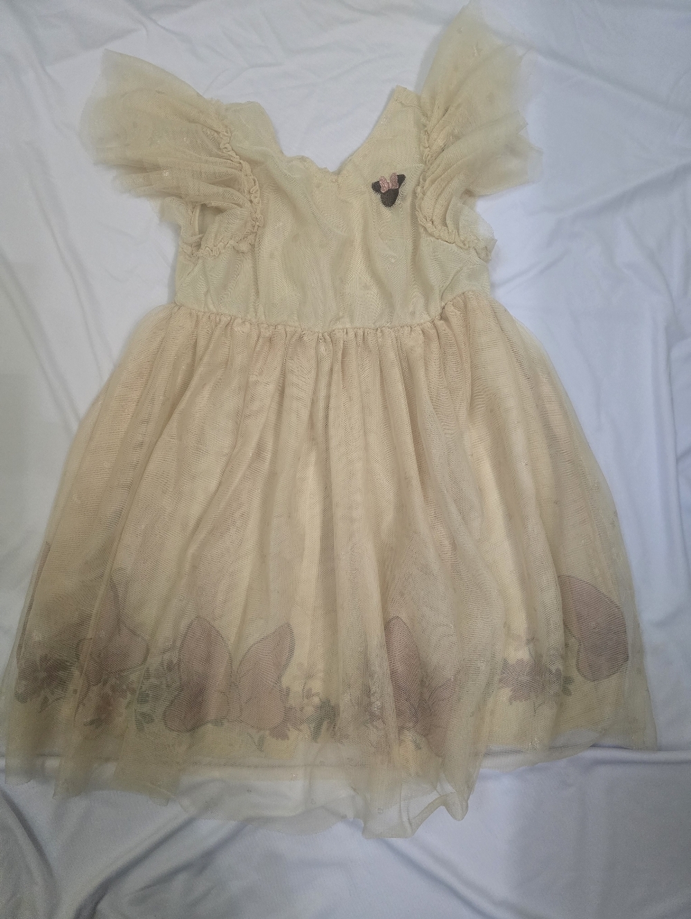 Beige Minnie Mouse Dress And A Green Dress With Pink Flowers.